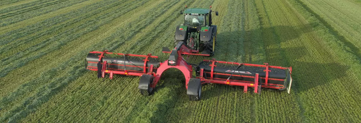 Merge Maxx harvesting grass in a green field