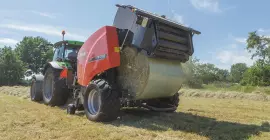 KUHN FB 3135 AUTOMATE викидає круглий тюк, обв’язаний плівкою.