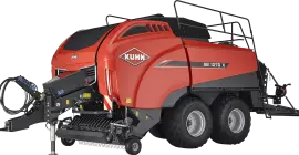 Великий тюковий прес-підбирач на тюкуванні соломи