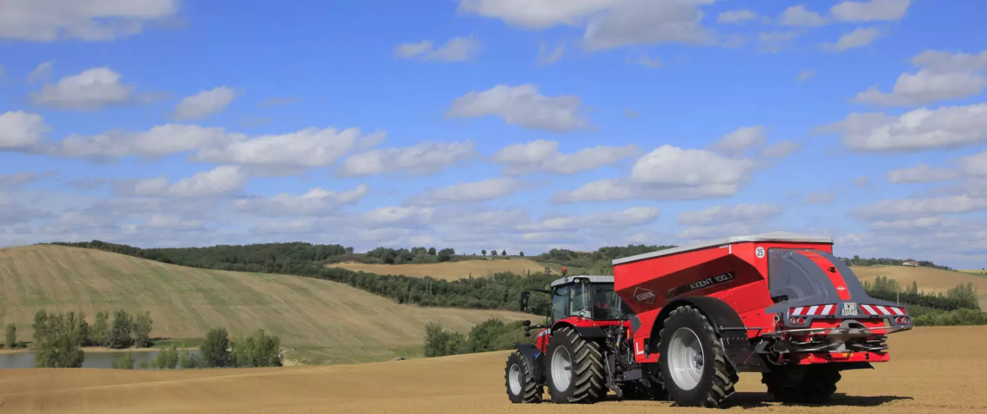 Розкидач добрив AXENT за роботою в полі